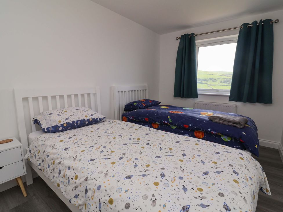 A bedroom with two beds and a window at 15 Chichester Park 