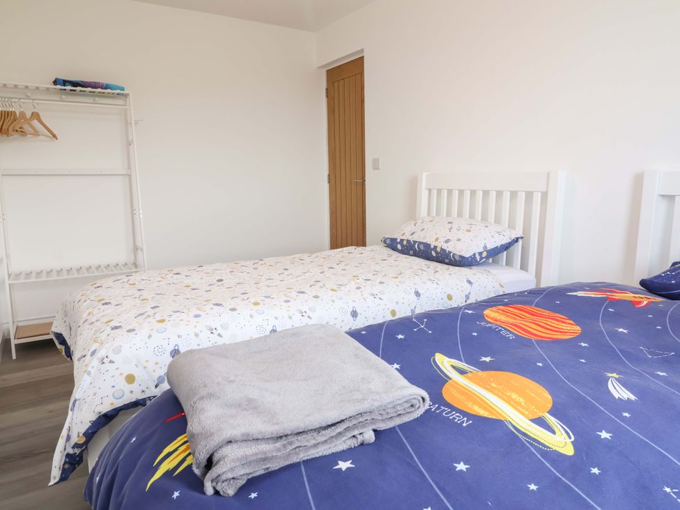 A bedroom with beds and a clothes rack at 15 Chichester Park