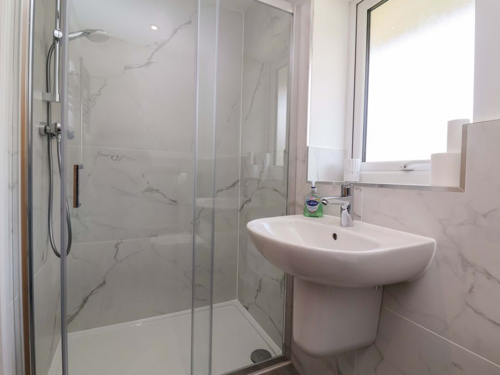 A bathroom with a shower and wash basin at 15 Chichester Park