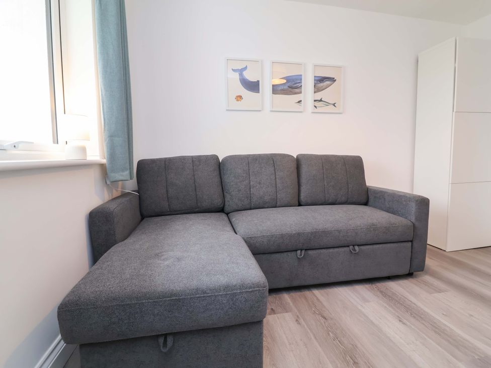 A living room with a grey sofa and artwork on the wall at Belvedere in Woolacombe