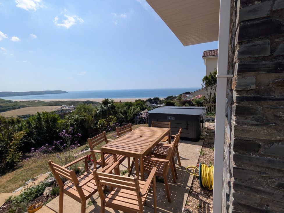 A garden with a dining table and chairs overlooking the ocean at Belvedere in Woolacombe