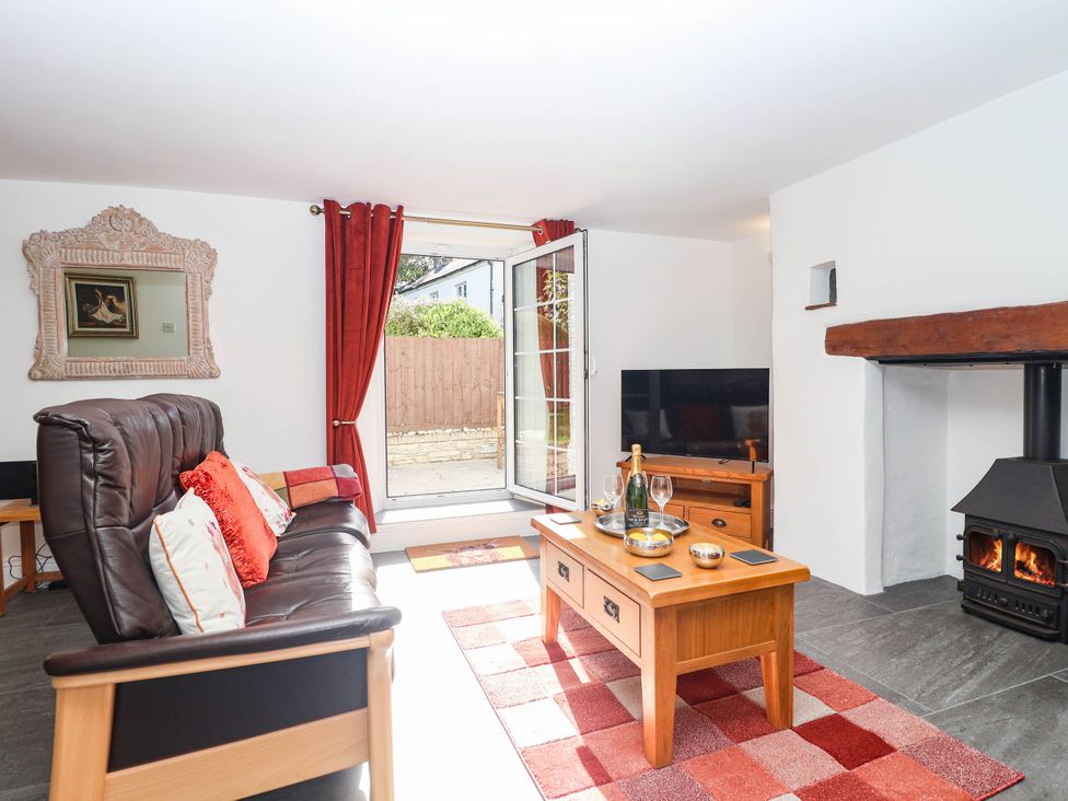 A living room with a sofa and coffee table at Swallow Cottage in Sheviock near Crafthole