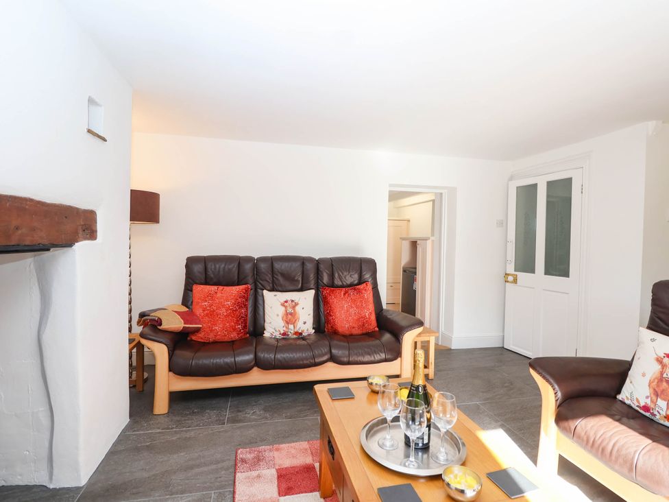 A living room with a sofa and coffee table at Swallow Cottage in Sheviock near Crafthole