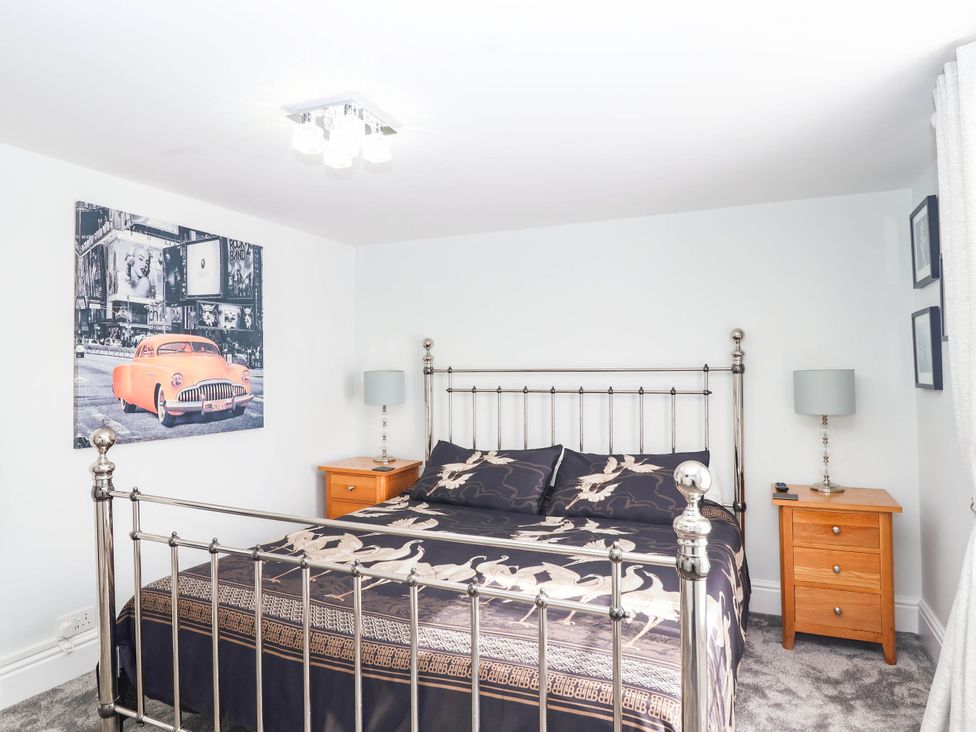 A bedroom with a bed and bedside tables at Swallow Cottage in Sheviock near Crafthole