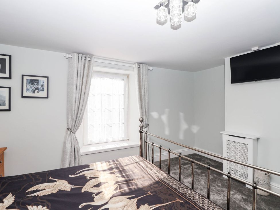 A bedroom with a bed and a window at Swallow Cottage in Sheviock near Crafthole