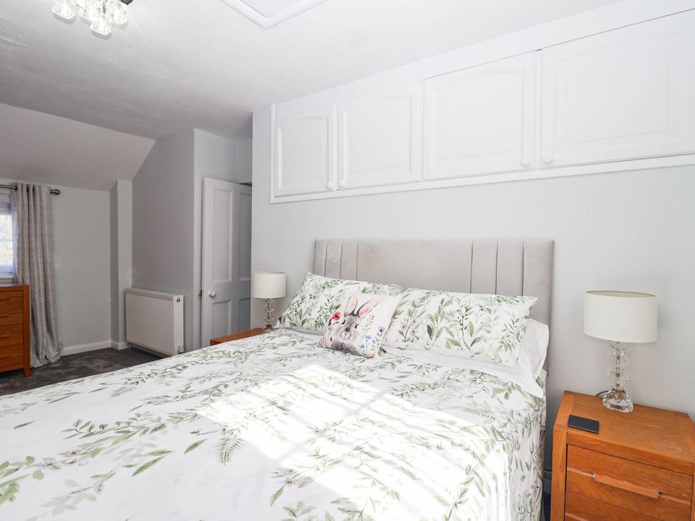 A bedroom with a bed and bedside table at Swallow Cottage Sheviock near Crafthole
