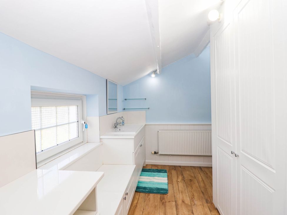 A laundry room with a sink and storage at Swallow Cottage Sheviock near Crafthole