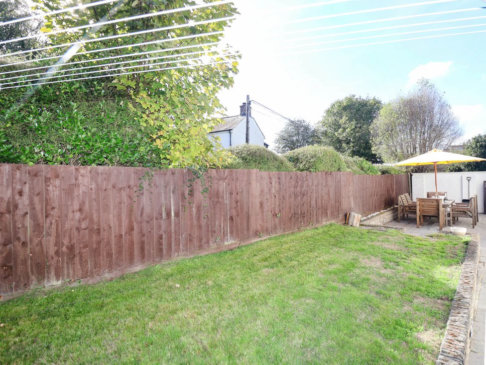 A garden with a fence and outdoor seating at Swallow Cottage in Sheviock near Crafthole