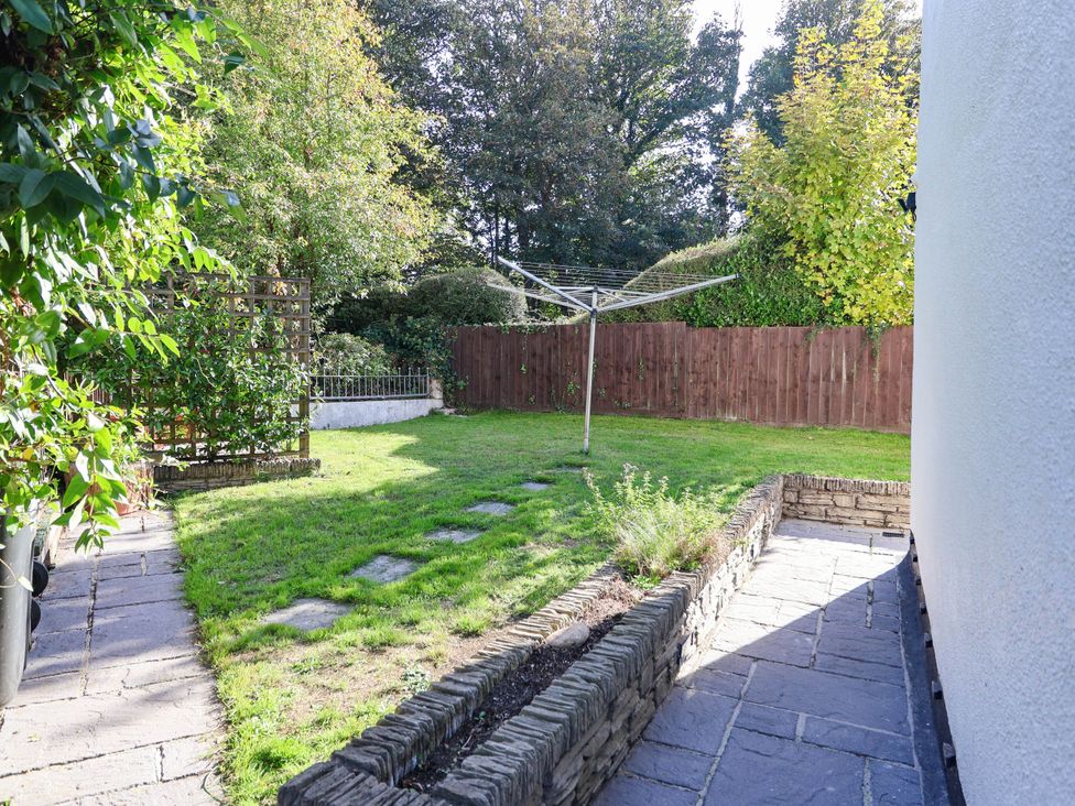 A garden with grass and a clothesline at Swallow Cottage in Sheviock near Crafthole