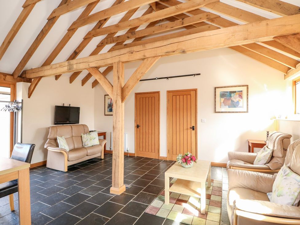 A living room with wooden beams and furniture at 5b Hideaways in Hunstanton