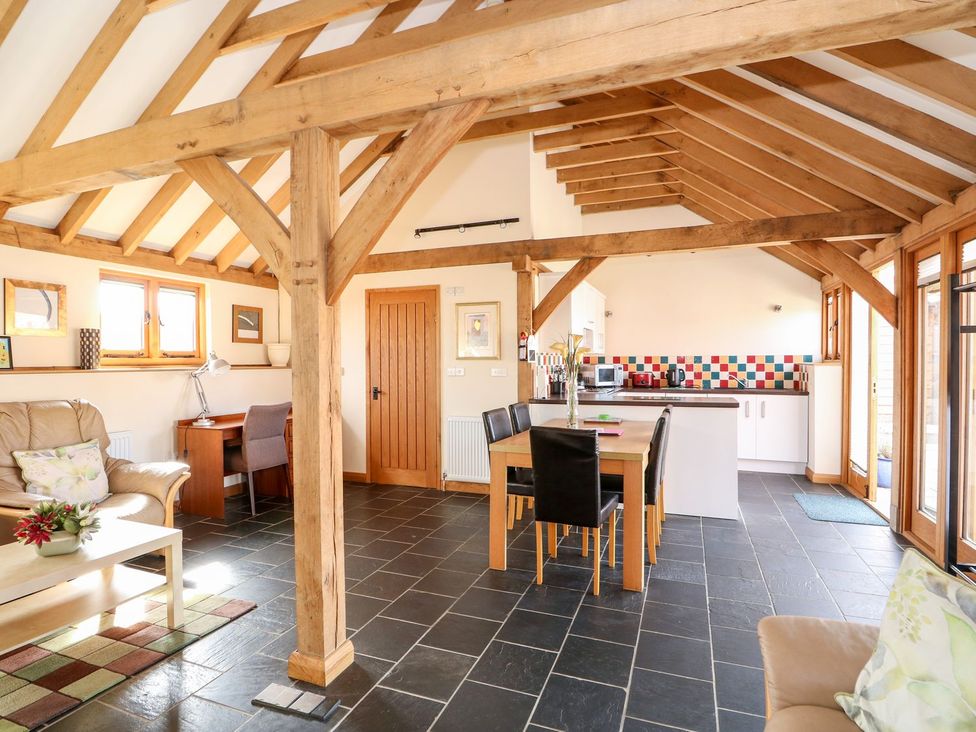 A living room with a sofa and dining area at 5b Hideaways in Hunstanton