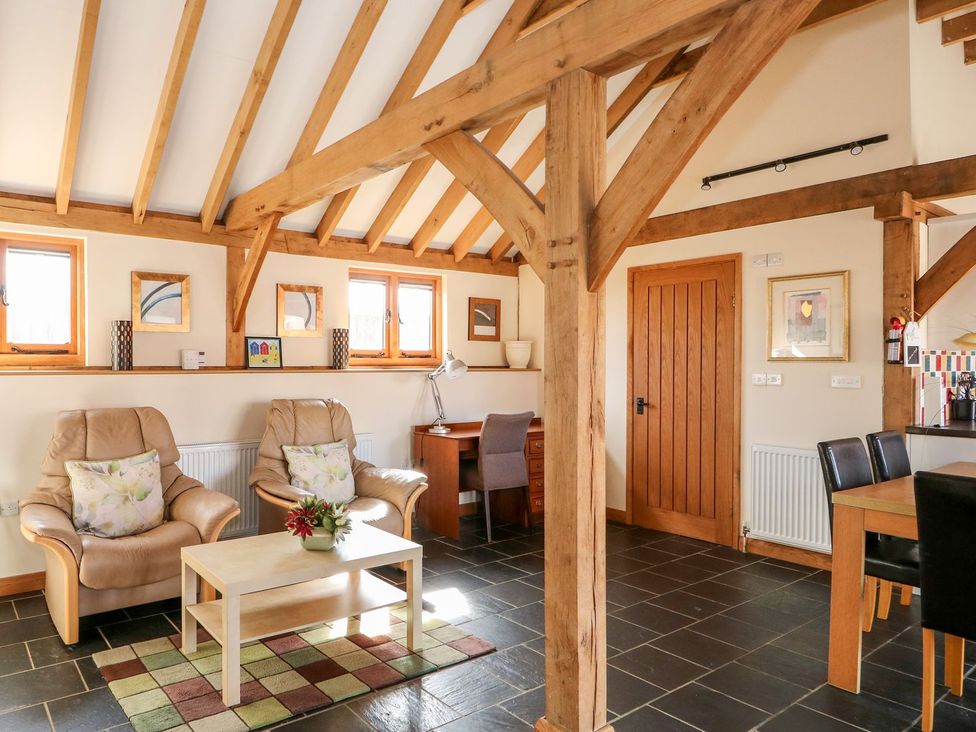 A living room with two armchairs and a wooden table at 5b Hideaways in Hunstanton
