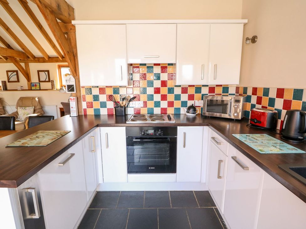A kitchen with a stove and microwave at 5b Hideaways in Hunstanton