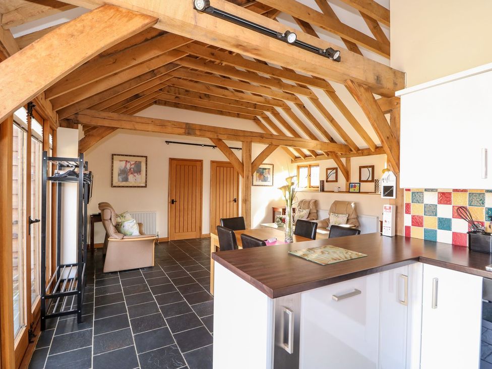 A conservatory with wooden beams and seating area at 5b Hideaways in Hunstanton