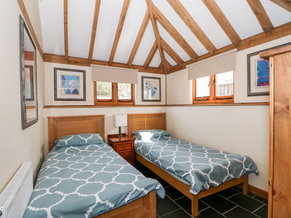 A bedroom with two single beds and windows at 5b Hideaways in Hunstanton