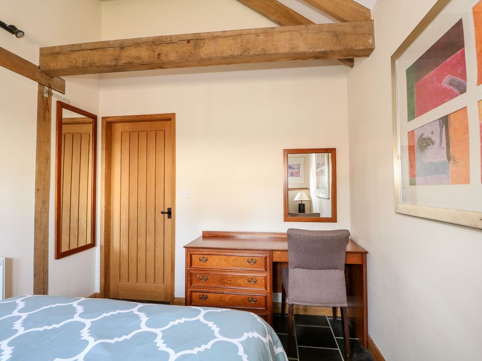 A bedroom with a bed, desk, chair, and mirror at 5b Hideaways in Hunstanton