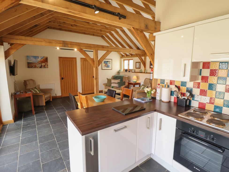 A kitchen with a stove and chairs at 3b Hideaways in Hunstanton