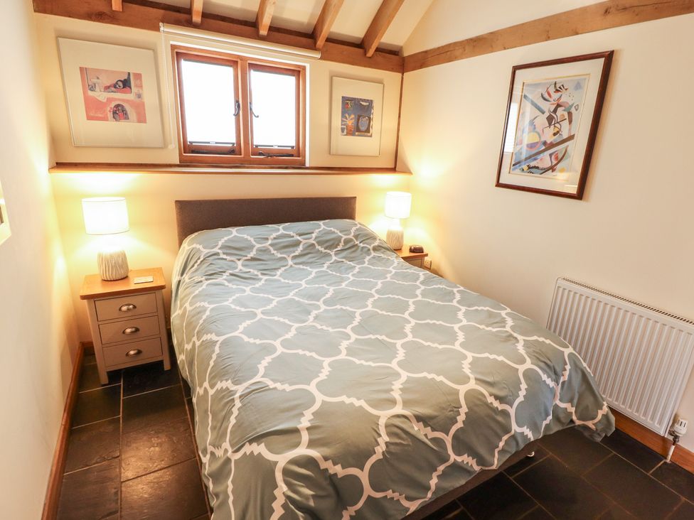 A bedroom with a bed and nightstand at 3b Hideaways Hunstanton