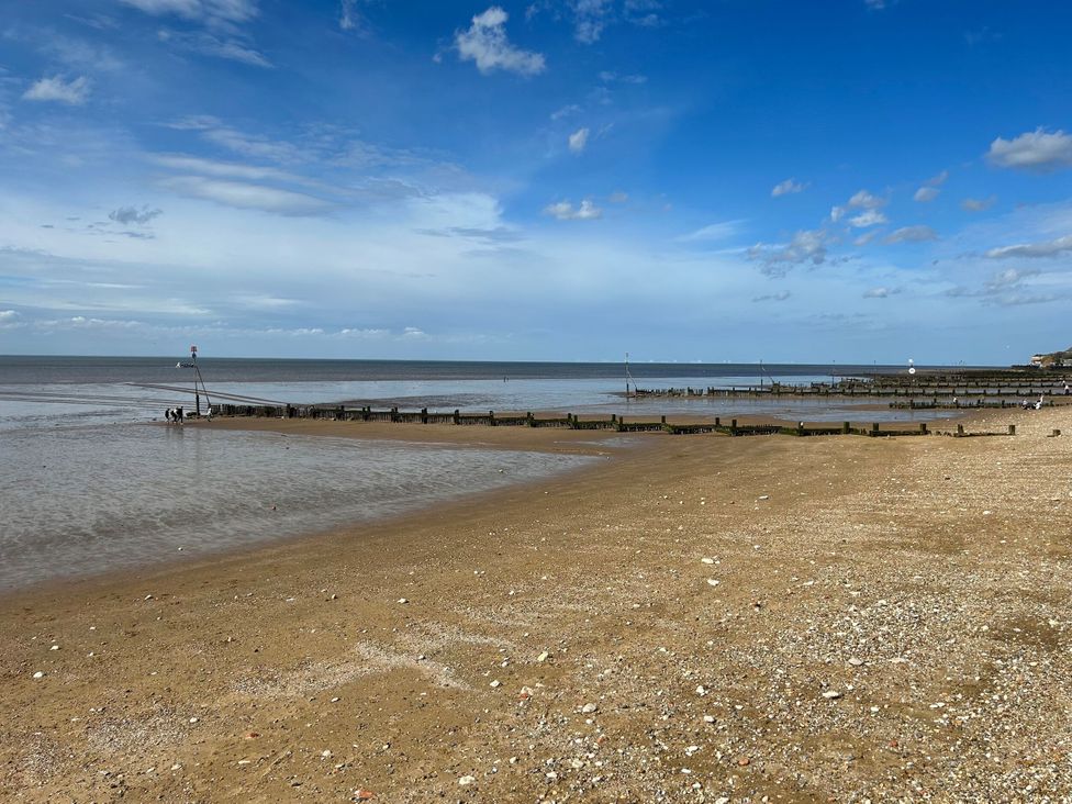 A beach with a pier and sea at 3b Hideaways in Hunstanton