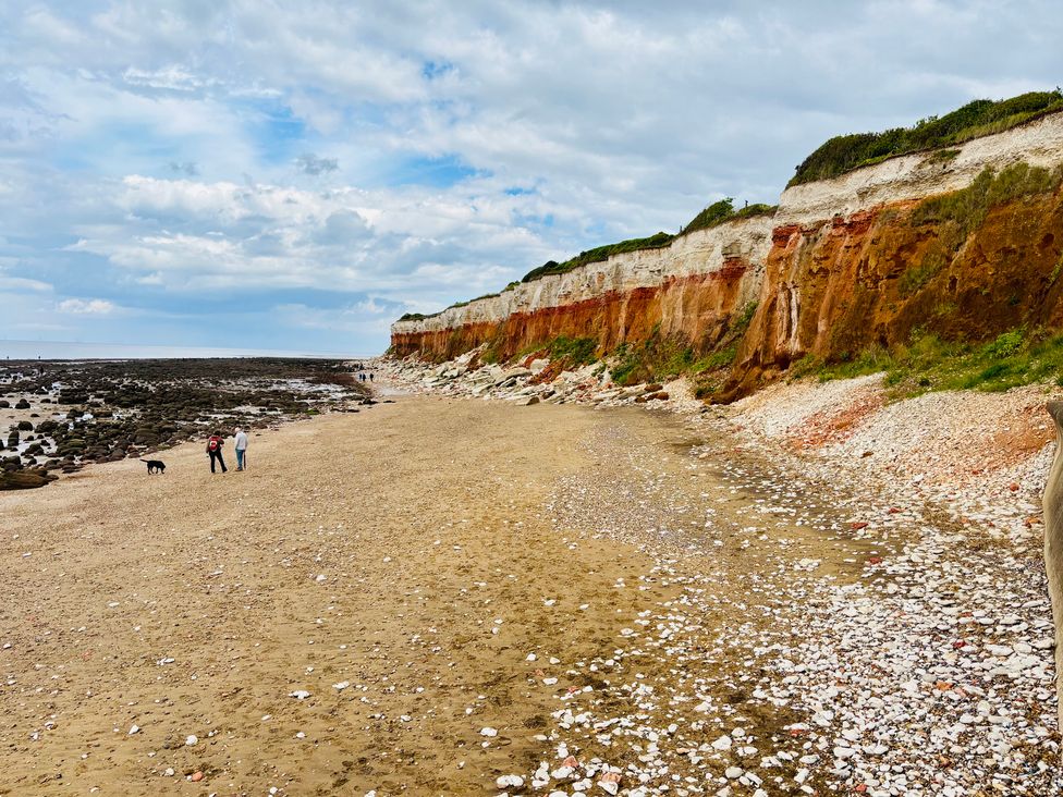 A beach with cliffs and people walking at 3b Hideaways in Hunstanton