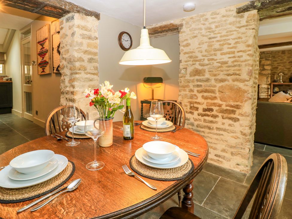 A dining room with a table set for a meal at Well Cottage in Charlbury