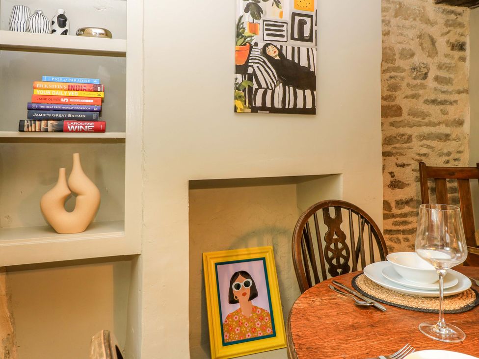 A dining room with books and artwork at Well Cottage in Charlbury