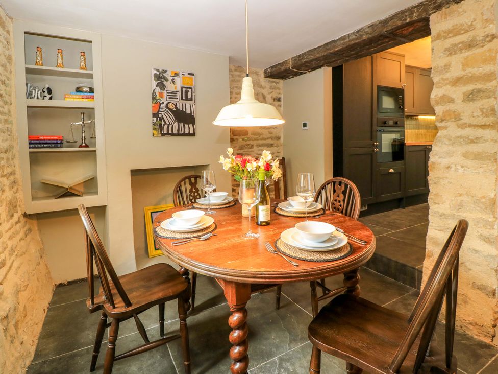 A dining room with a table set for meals at Well Cottage in Charlbury