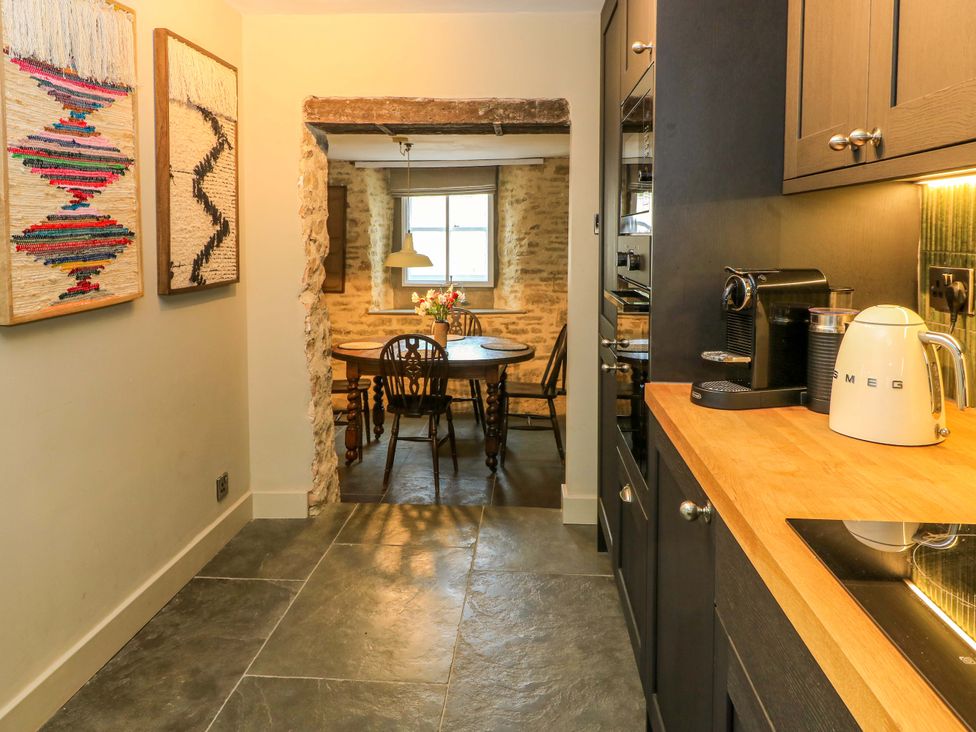 A kitchen with a table and chairs at Well Cottage Charlbury