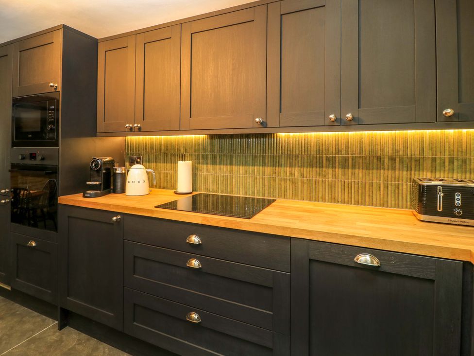 A kitchen with cabinets, oven, coffee machine, kettle at Well Cottage in Charlbury