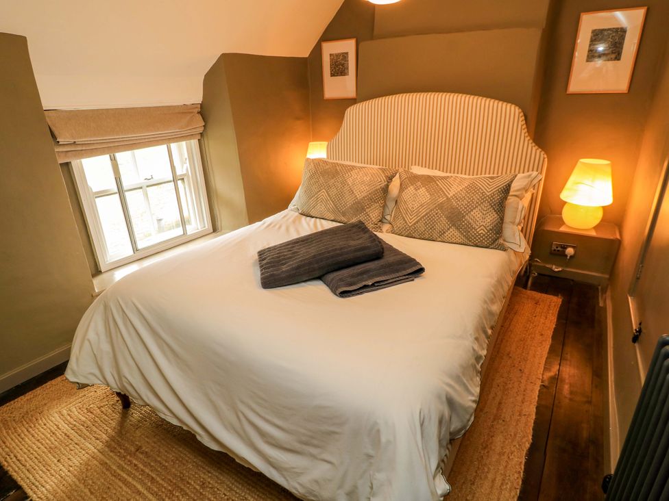 A bedroom with a bed and lamp at Well Cottage in Charlbury