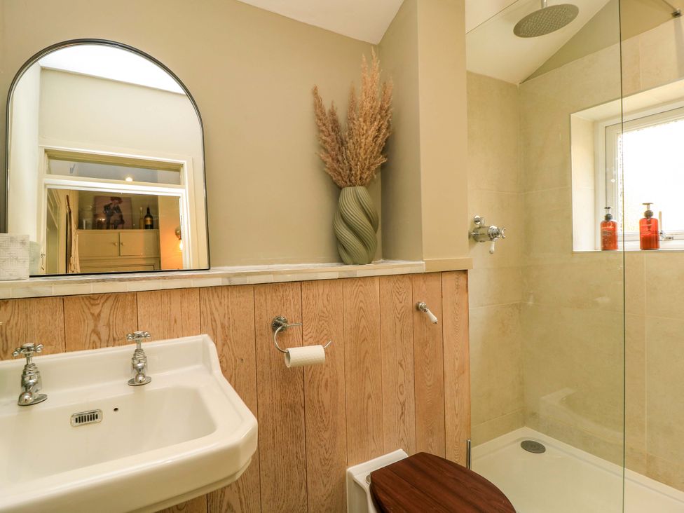 A bathroom with a sink, toilet, and shower at Well Cottage in Charlbury