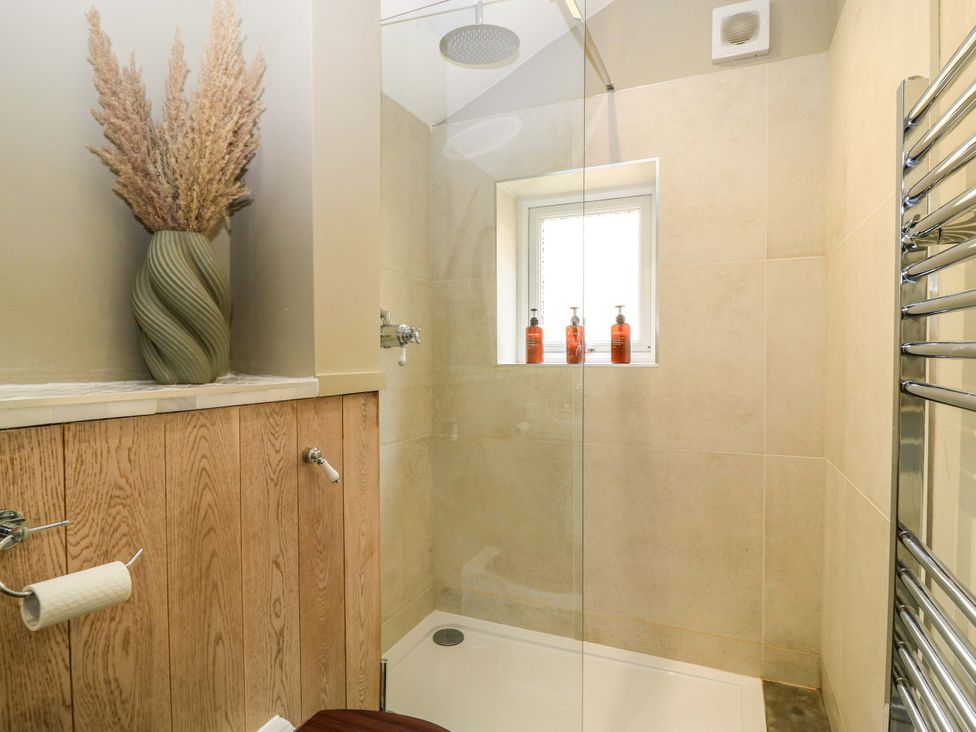 A bathroom with a shower and towel radiator at Well Cottage Charlbury