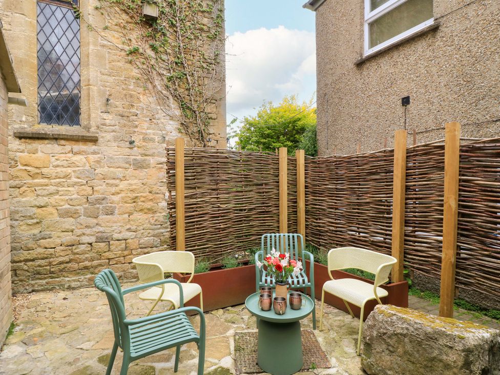A garden area with seating and plants at Well Cottage in Charlbury