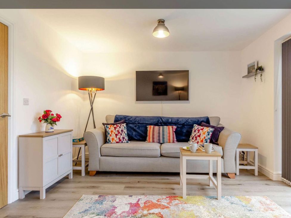 A living room with a sofa and coffee table at Buttercup Cottage in Wadebridge