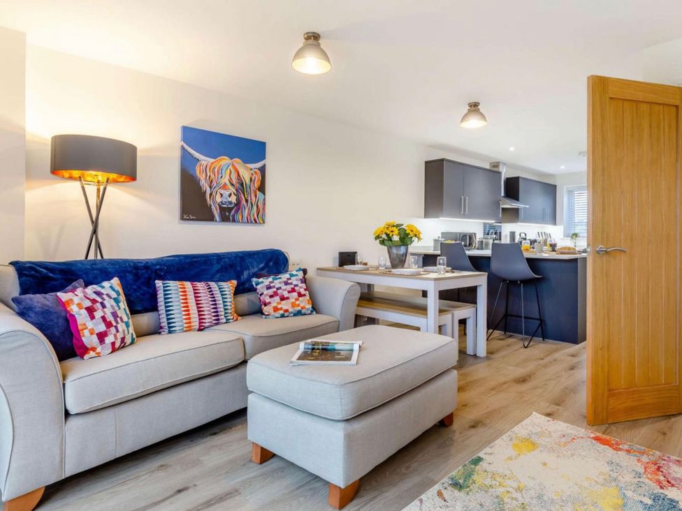 A living room with a sofa and table at Buttercup Cottage in Wadebridge