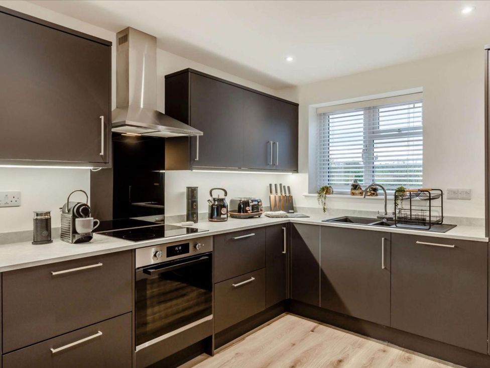A kitchen with modern appliances and sink at Buttercup Cottage in Wadebridge