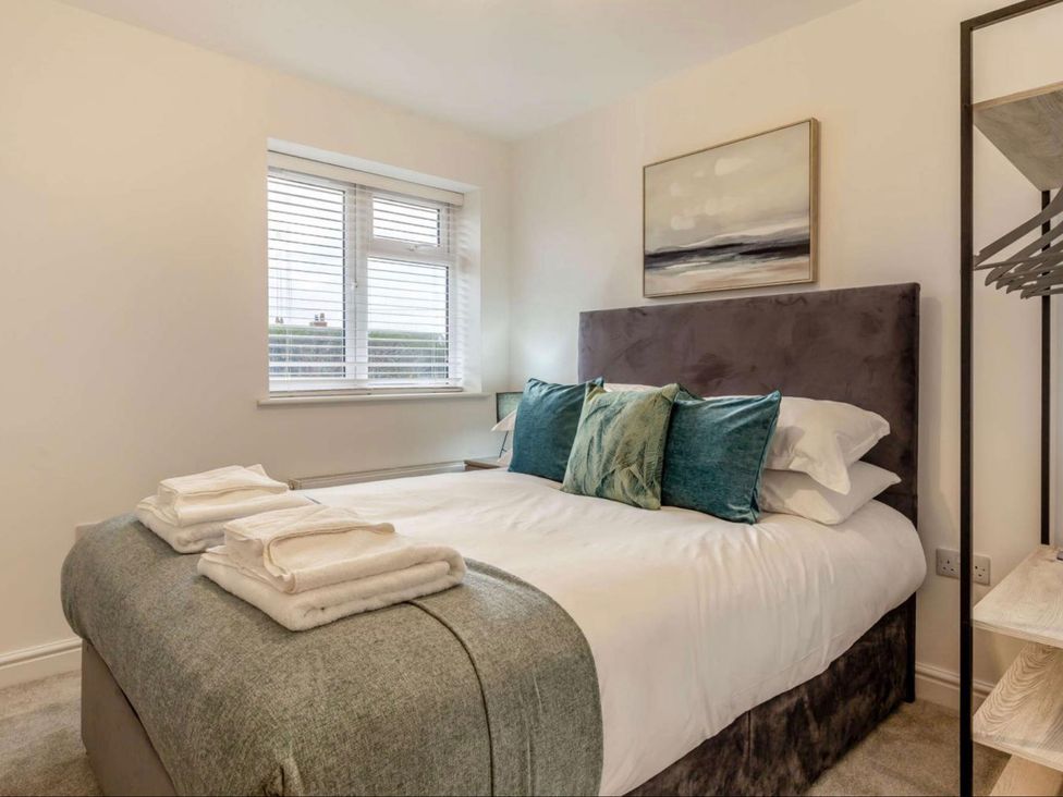 A bedroom with a bed and pillows at Buttercup Cottage in Wadebridge