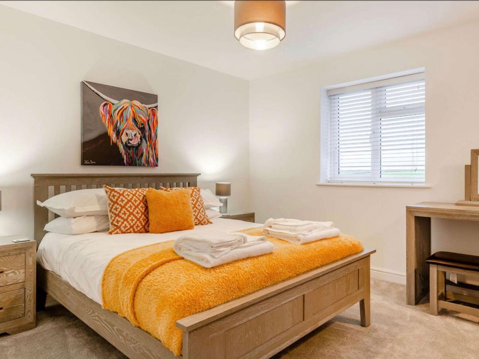 A bedroom with a bed and a desk at Buttercup Cottage in Wadebridge