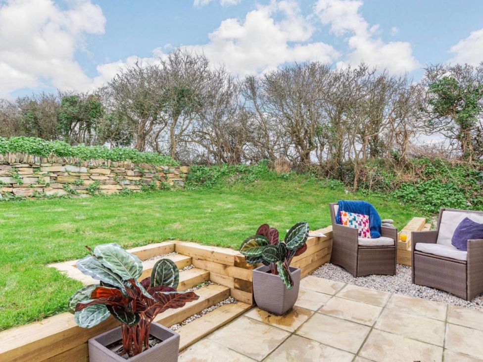 A garden with seating and planters at Buttercup Cottage in Wadebridge