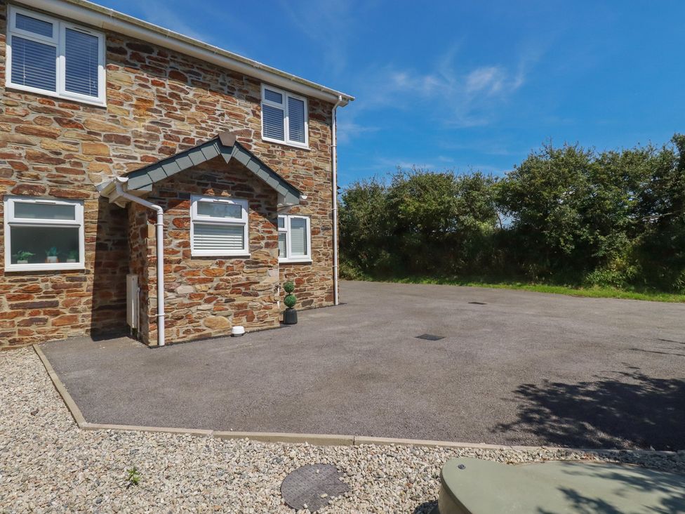 An outdoor area with a stone wall and pathway at Buttercup Cottage St Merryn