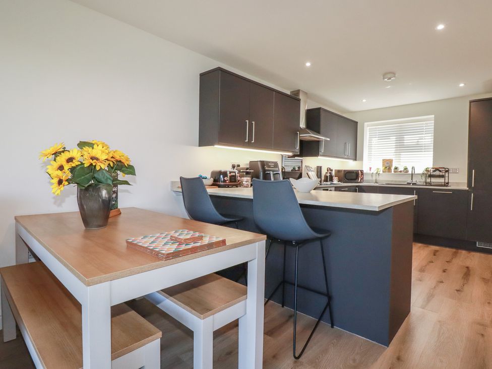 A kitchen with a table and chairs at Buttercup Cottage St Merryn