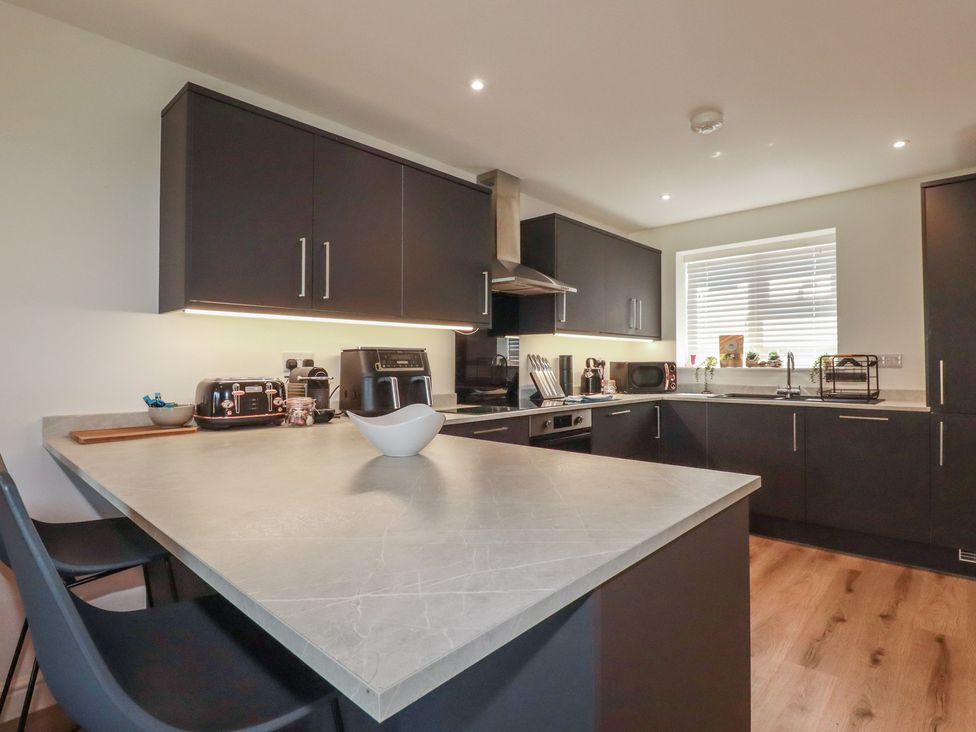 A kitchen with countertop and appliances at Buttercup Cottage in St Merryn