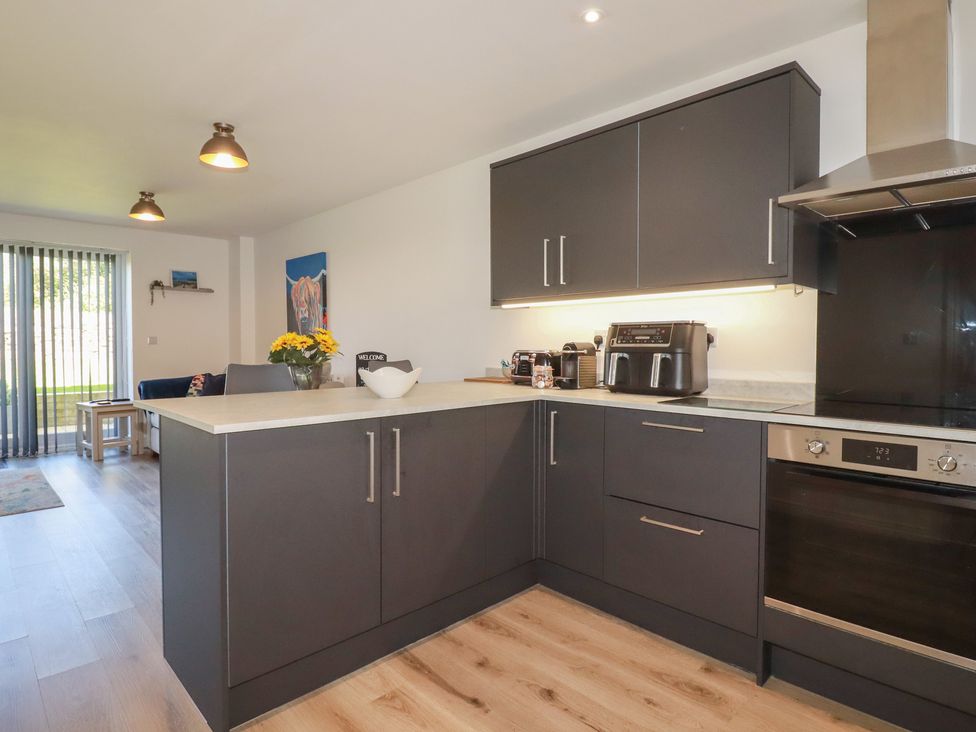 A kitchen with cabinets and appliances at Buttercup Cottage in St Merryn