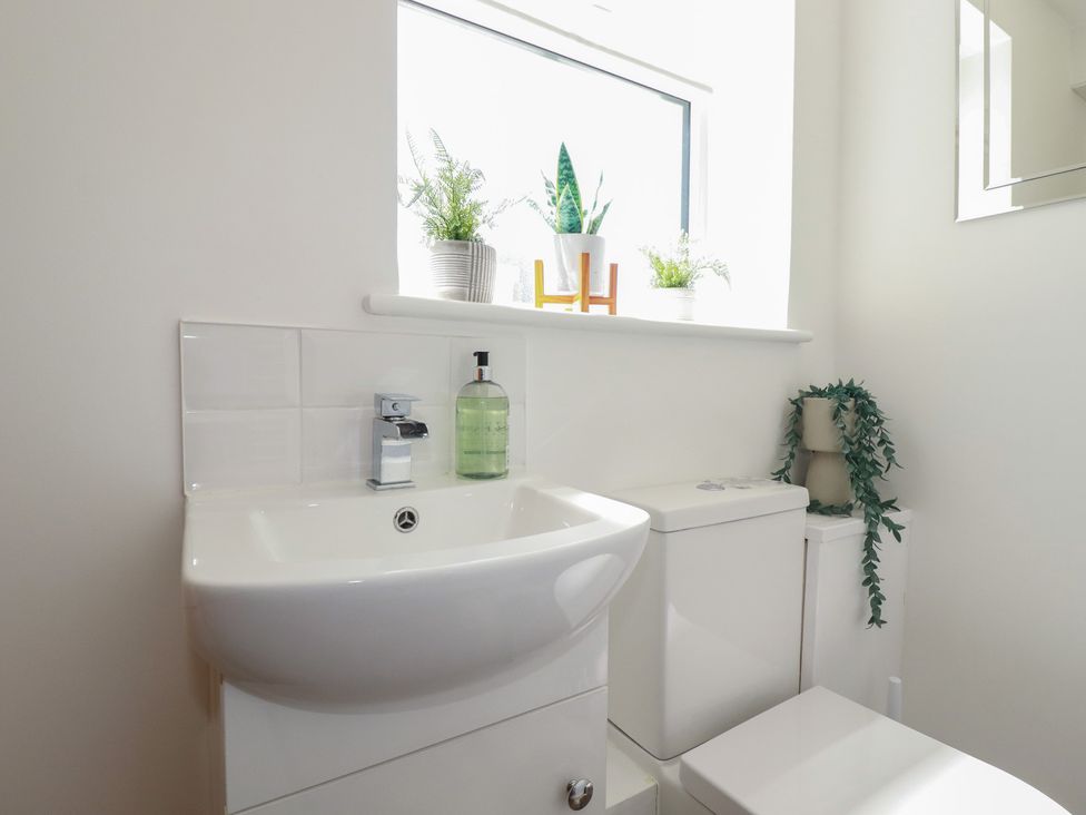 A bathroom with a sink and toilet at Buttercup Cottage in St Merryn
