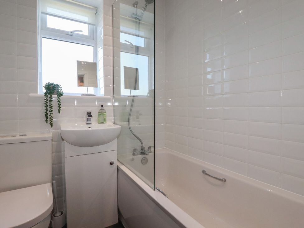 A bathroom with a bathtub and sink at Buttercup Cottage in St Merryn