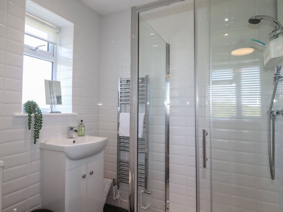 A bathroom with a shower and sink at Buttercup Cottage in St Merryn