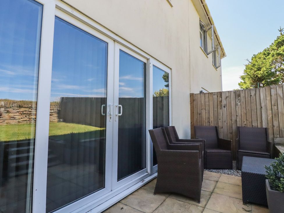 A garden with chairs and a table at Buttercup Cottage in St Merryn