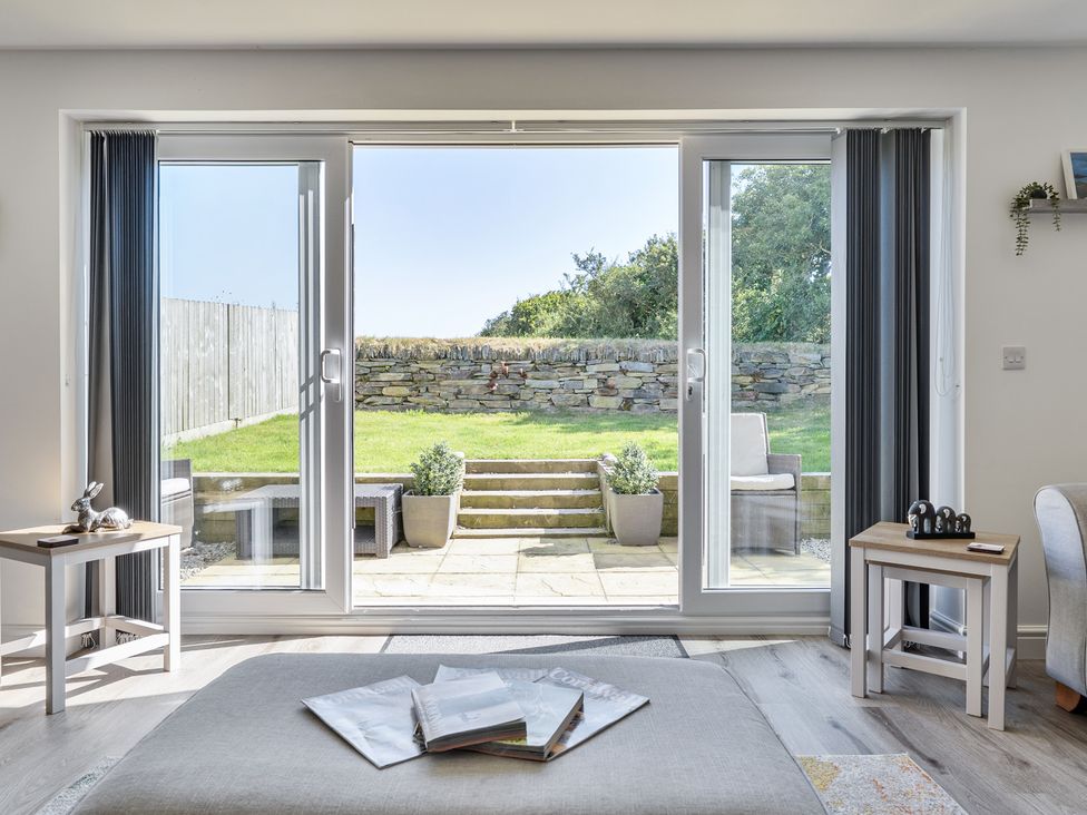 A living room with a view of the garden at Buttercup Cottage in St Merryn
