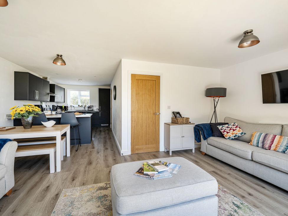 A living room with a sofa and coffee table at Buttercup Cottage St Merryn