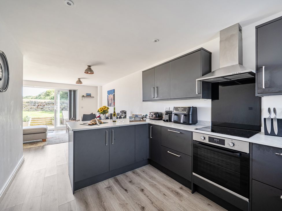 A kitchen with modern appliances at Buttercup Cottage in St Merryn
